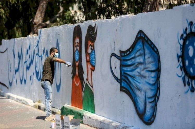 صور فنانون في دير البلح  يرسمون جداريات توعوية للمواطنين وسط قطاع غزة