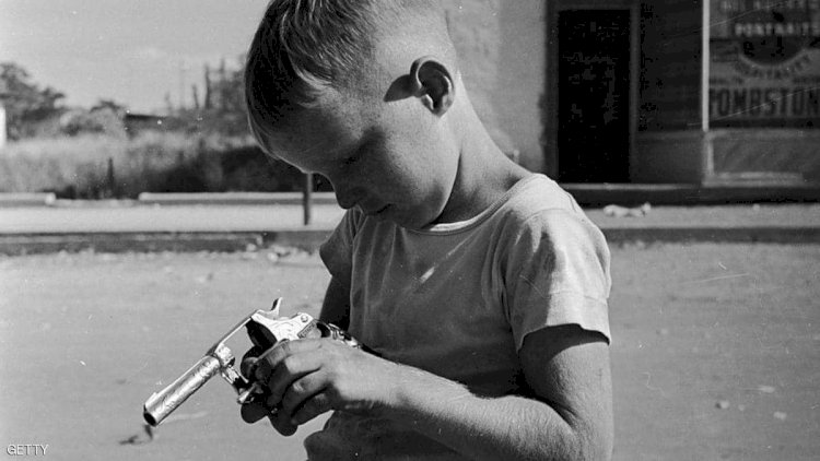 طفل أميركي يلهو بمسدس