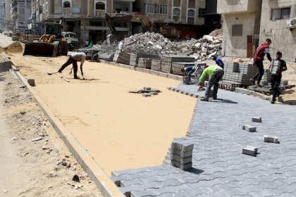 عمال فلسطينيون يصلحون الطرق التى دمرت خلال التصعيد الأخير على قطاع غزة