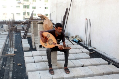 العازف "أبو غبن" يعمل في البناء لإعالة أسرته