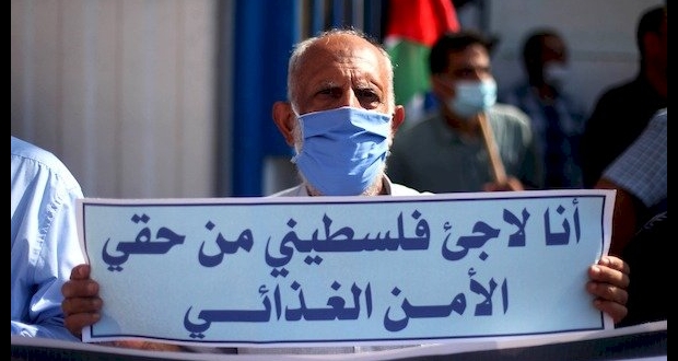 غزة: لاجئ فلسطيني يرفع يافطة تطالب وكالة اونروا بتوفير الأمن الغدائي