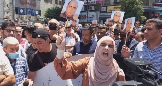 فلسطينية تحمل صورة لنزار بنات أثناء وقفة احتجاجية في وسط رام الله 